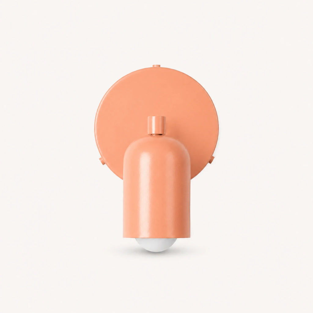 Adjustable spot LED Nordic wall light in pink from the front — swivel spot head and slim wall mount detail.