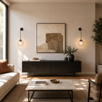 Black clear amber glass hook arm Nordic wall sconces flanking artwork above sideboard console in contemporary living room