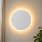 Black halo motion sensor LED modern wall light — white version with motion sensor activated.