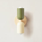 Colourful Nordic indoor wall light — green and white cylindrical shades on a cream backplate for a soft natural Scandinavian look.
