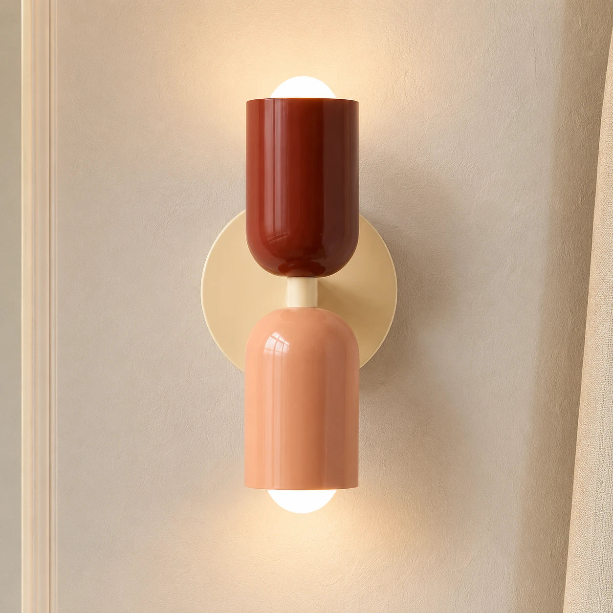 Colourful Nordic indoor wall light — red and pink cylindrical shades on a cream backplate for a warm romantic feel.