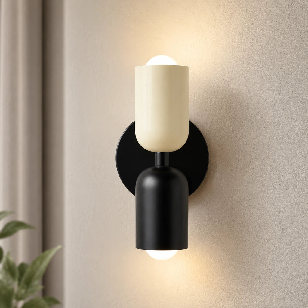 Colourful Nordic indoor wall light — white cylindrical shades on a black backplate for a clean monochrome modern look.