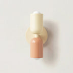 Colourful Nordic indoor wall light — white and pink cylindrical shades on a cream backplate for a soft pastel bedroom look.