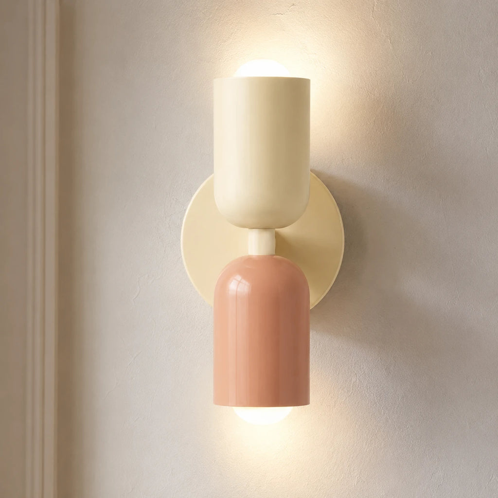 Colourful Nordic indoor wall light — white and pink cylindrical shades on a cream backplate for a soft pastel bedroom look.