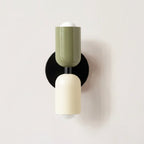Colourful Nordic metal wall light with two cylindrical shades in green and white on a black base, casting light up and down