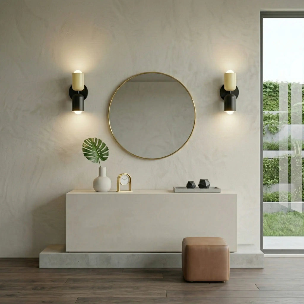Pair of Nordic metal wall lights with cream cylindrical shades on black bases, mounted either side of a round mirror in a modern hallway