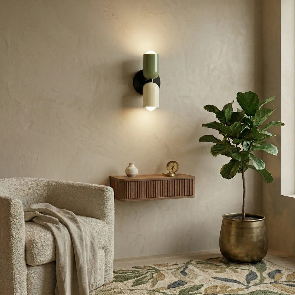 Colourful Nordic metal wall light with green and cream cylindrical shades mounted in a modern living room, casting a warm ambient glow up and down