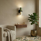 Colourful Nordic metal wall light with green and cream cylindrical shades mounted in a modern living room, casting a warm ambient glow up and down