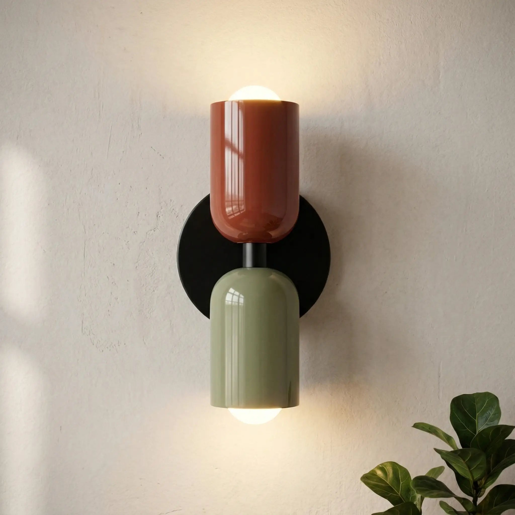 Colourful Nordic metal wall light with two cylindrical shades in red and green on a black base, casting a warm ambient glow up and down
