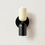 Colourful Nordic metal wall light with two cylindrical shades in white and black on a black base, casting light up and down