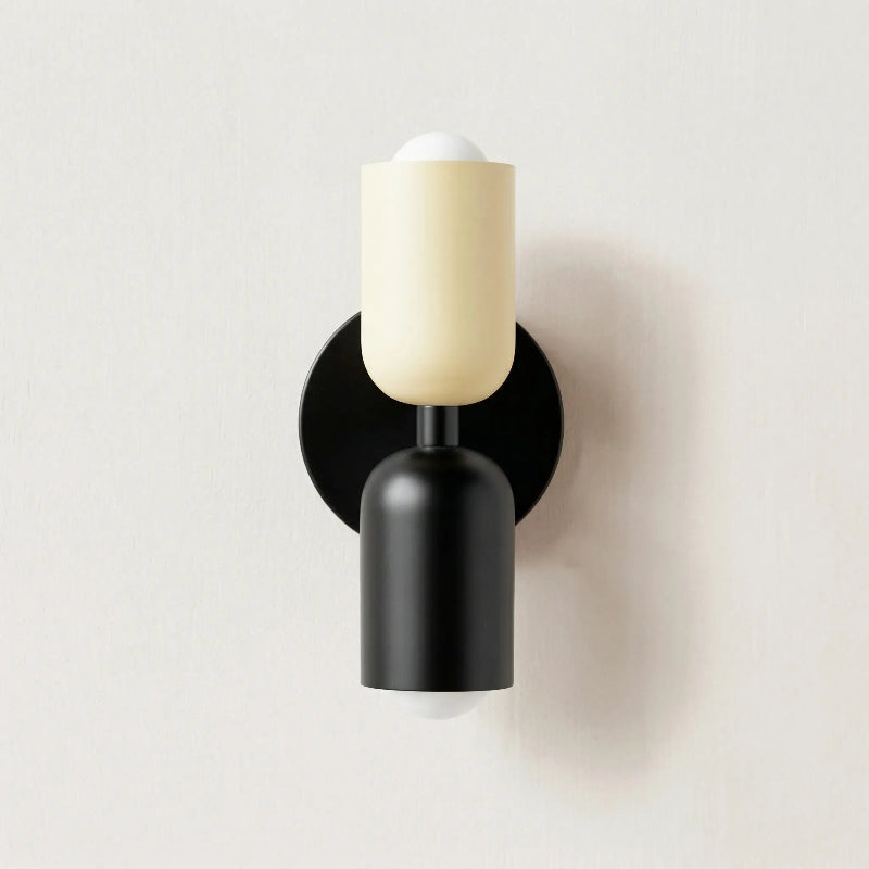 Colourful Nordic metal wall light with two cylindrical shades in white and black on a black base, casting light up and down