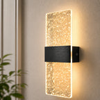 Decorative acrylic contemporary LED wall sconce with glowing crystal panel and sleek brushed black hardware on white background