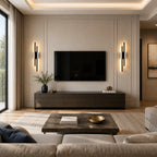 Black double strip LED wall lights flanking a wall-mounted TV in an elegant modern living room with marble coffee table
