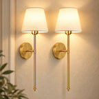 Pair of gold fabric mid-century wireless wall sconces mounted together, each with a tapered fabric shade on a slim stem.