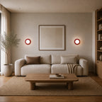 Pair of Mini Glass Orb Nordic Wall Lights in red flanking a sofa in a warm minimal living room