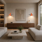Pair of orange swing arm retro wall lights flanking a sideboard and artwork in an open-plan modern living room