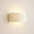 Ribbed resin Nordic wall light in cream — clean product view of the ribbed cylindrical shade in neutral cream finish.