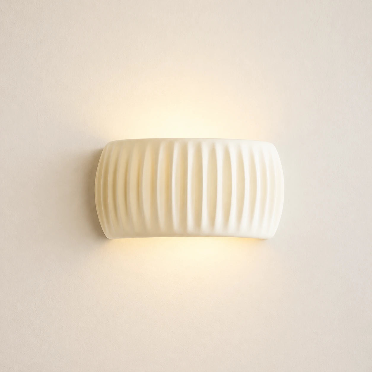 Ribbed resin Nordic wall light in cream — clean product view of the ribbed cylindrical shade in neutral cream finish.