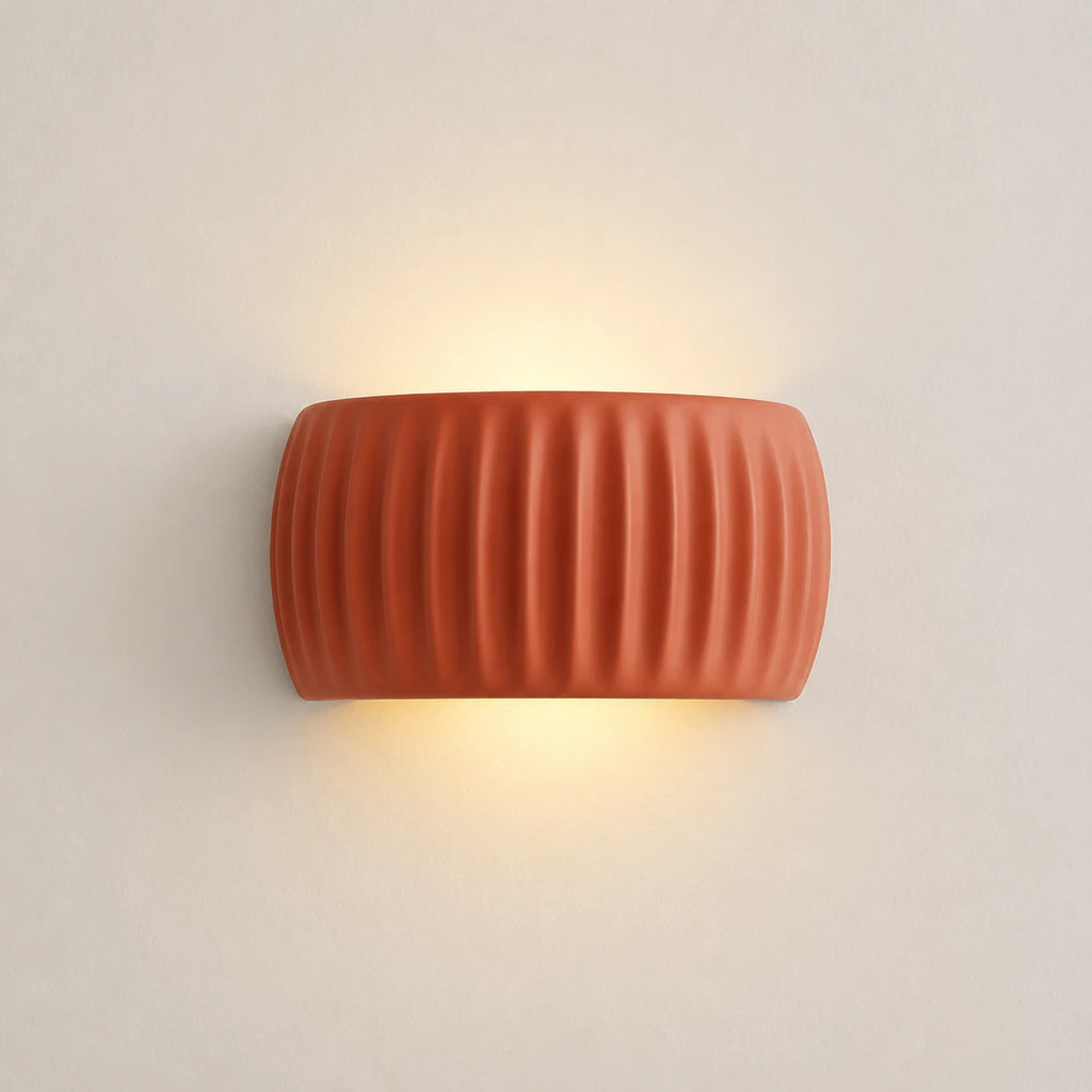 Ribbed resin Nordic wall light in terracotta — clean product view of the ribbed cylindrical shade in warm earthy finish.