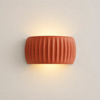 Ribbed resin Nordic wall light in terracotta — clean product view of the ribbed cylindrical shade in warm earthy finish.
