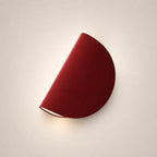Rotating half-disc LED modern wall light in red — a vibrant colour accent for contemporary and eclectic bedroom walls.
