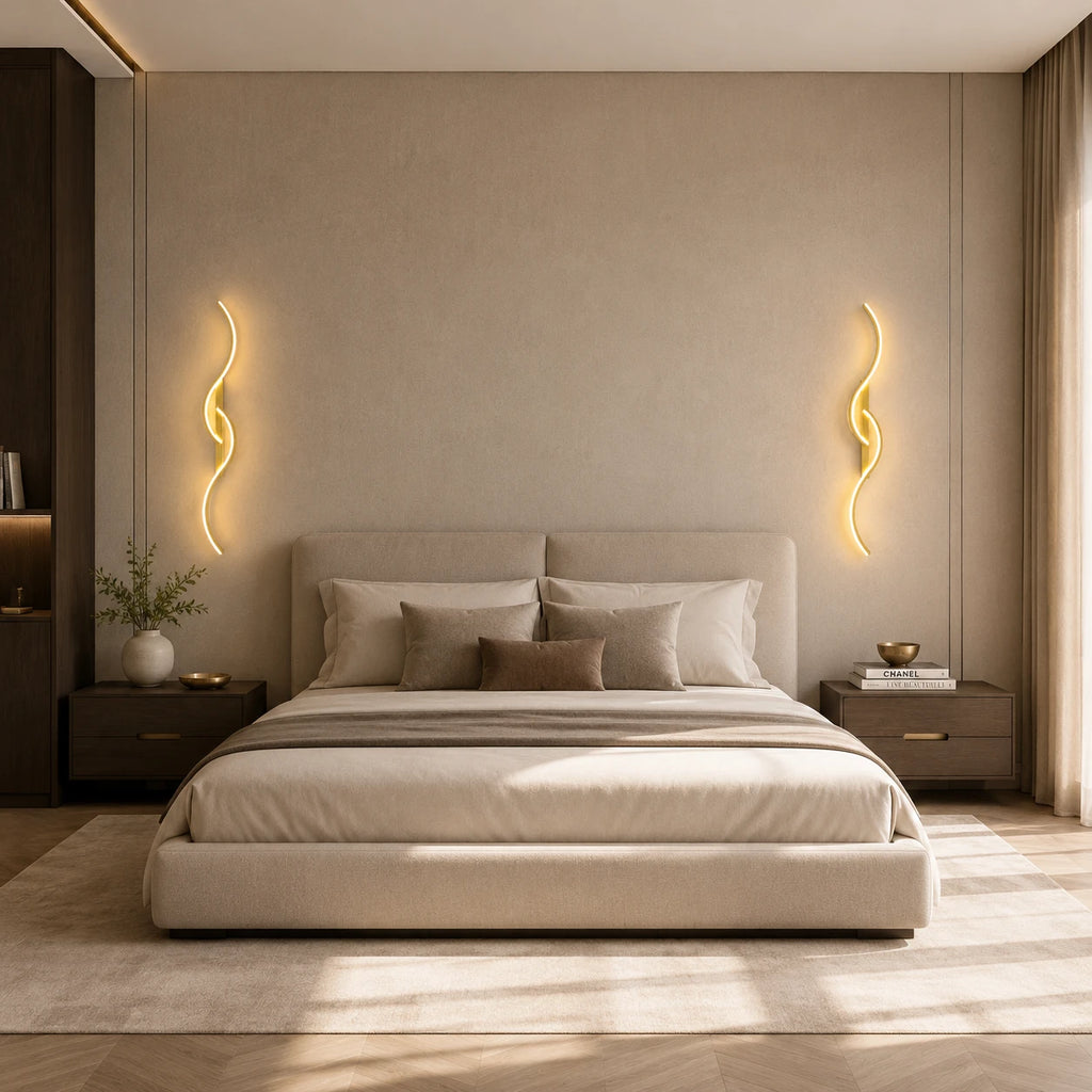Pair of gold sculptural dual-curve LED wall lights either side of a bed in a luxury neutral bedroom