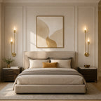 Gold twin arm candle modern wall sconces as bedside reading lights flanking framed artwork in elegant neutral bedroom