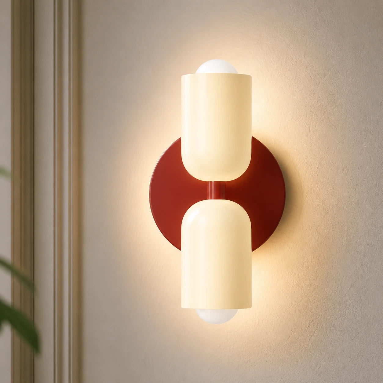 Two-tone Nordic indoor LED wall light with cream cylindrical shades on a red backplate casting warm ambient glow up and down.