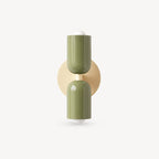 Two-tone Nordic indoor wall light — olive green cylindrical shades on a cream backplate for earthy biophilic Nordic interiors.