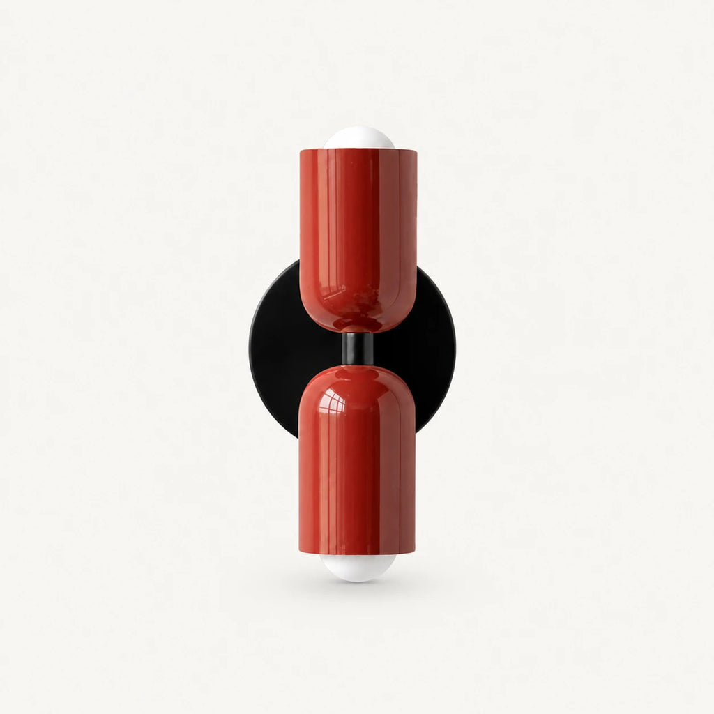 Two-tone Nordic indoor wall light — red cylindrical shades on a black circular backplate for a bold contrast statement wall.