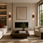 Pair of red two-tone Nordic up and down wall lights flanking a stone fireplace in a neutral living room.