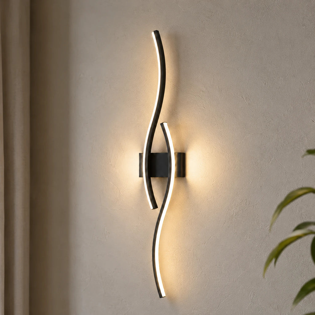 Wave LED modern wall light close up — the curved LED panel lit brightly against a white wall.